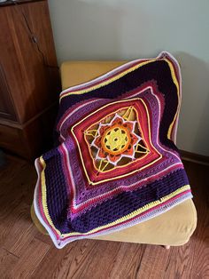 a crocheted blanket sitting on top of a chair