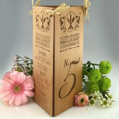 a wooden wine box with the number two on it and flowers around it, in front of a gray background