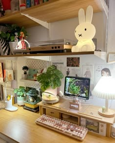 a desk with a computer, keyboard and lamp on it in front of a bookshelf