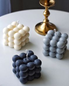 three small pieces of fruit sitting on top of a white table next to a candle