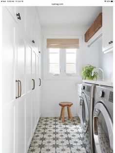 a washer and dryer in a small room with white walls, flooring and cabinets