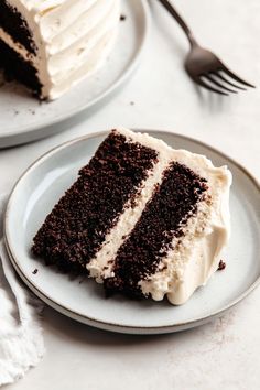 two plates with slices of chocolate cake on them and one slice has white frosting