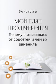 an open book sitting on top of a white bed next to two orange circles and hearts