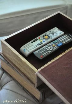 two remote controls in a wooden box on a couch