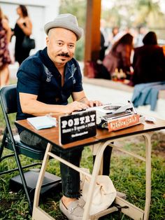 a man sitting at a table with a record player on it