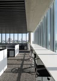 an empty office with lots of desks and chairs in front of large windows overlooking the city