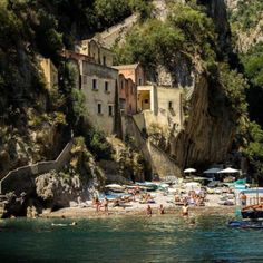 people are on the beach in front of an old building