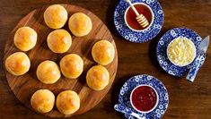 small rolls and sauces on plates next to a plate with honey dipping sauce in it