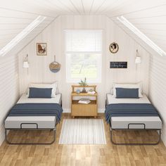 two beds in a room with white walls and wooden floors