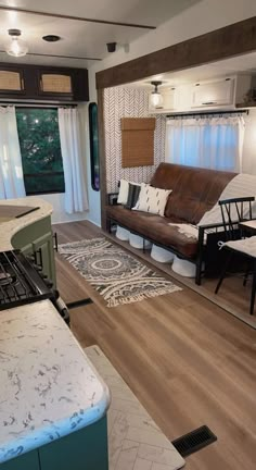 a living room filled with furniture and a stove top oven next to a kitchen counter