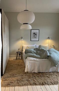 a bed sitting in a bedroom on top of a wooden floor next to two lamps