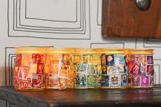 several jars filled with different types of money sitting on top of a wooden table next to a wall