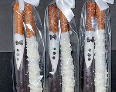 four carrots wrapped in plastic with bow ties and white powdered sugar on them