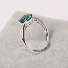 a close up view of a ring with a green stone on the top and side