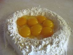 eggs are in the middle of some flour