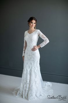 a woman in a wedding dress posing for the camera with her hands on her hips