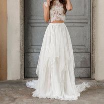 a woman standing in front of a door wearing a white dress