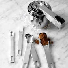 the kitchen utensils are next to each other on the marble counter top with spices