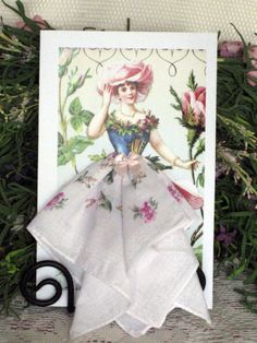 there is a card with an image of a woman in a dress and hat on it