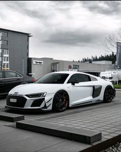 a white audi sports car parked in front of a building