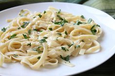 a white plate topped with pasta covered in sauce