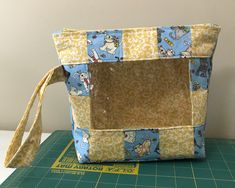 a small purse sitting on top of a green cutting board next to a white wall