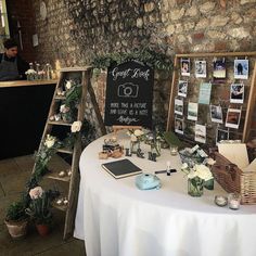 the table is set up for an event with pictures and flowers on it, along with other decorations