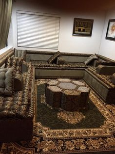 a living room with couches and rugs on the floor in front of a window