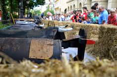 an outdoor event with hay bales on the ground and people standing around looking at them