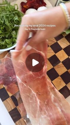 a person cutting meat on top of a wooden table