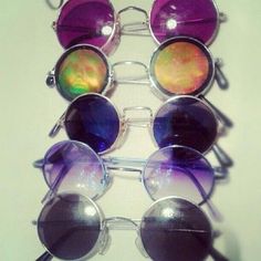 several pairs of sunglasses sitting on top of each other in front of a white wall