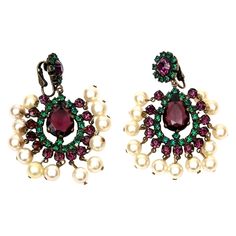 This pair of stunning vintage Kenneth Jay Lane 1960's rhinestone, gilt metal and faux pearl clip on dangle chandelier earrings are for sure dramatic on. They are signed KJL. These are perfect for your casual wear, evening attire and formal wear. The jewel tone colors and regality of the purple and green rhinestones will add conversation. The faux pearl dangle at the bottom adds movement. Please verify dimensions with us. They are aprox. 3 " H/ L. These have been in our archives now for over 25 y Luxury Antique Clip-on Earrings For Formal Occasions, Fancy Sapphire, White Diamond Earrings, Contemporary Jewelry Design, Jewel Tone Colors, Peridot Earrings, Purple Pearl, Moonstone Earrings, Stunning Earrings