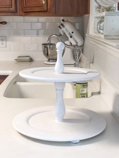 a kitchen counter with a white cake stand on it