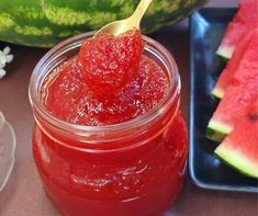 a jar filled with jam next to watermelon slices