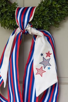 a patriotic wreath with red, white and blue ribbons