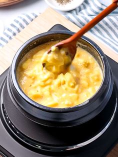 a spoon in a pot filled with food on top of an electric stove burner