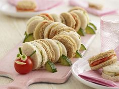 several sandwiches are arranged on a pink cutting board