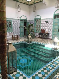 an indoor swimming pool surrounded by green and white tiles