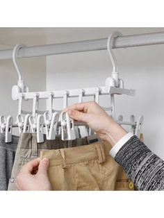 a person is hanging clothes on a rail