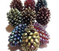 several different colored pine cones on a white surface