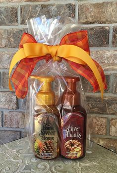 two bottles of hand sanitizers in front of a brick wall with a bow