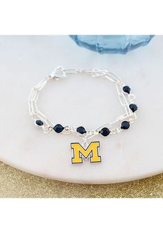 Accessorize your Wolverines game day style with this Michigan Wolverines Paperclip Chain and Enamel Logo Womens Bracelet. This Womens Bracelet features a team logo and team colors. Silver plated chain bracelet with team color rhinestones and beads, Connects with an enamel team logo charm, Charm measures around 1", The perfect game day accessory!, Show off your team spirit in style! Michigan Wolverines Outfit, Go Blue Michigan Wolverines, Michigan Wolverines Hockey, Michigan Wolverines Apparel, Minnesota United Fc, Tyler Seguin, Womens Bracelet, Nba Hats, Sporting Kansas City