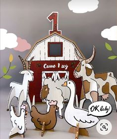 some animals are standing in front of a barn with a number one sign on it