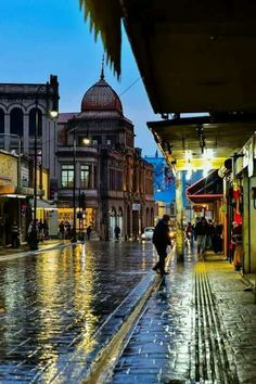 a person walking down a wet street in the rain