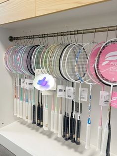 there are many tennis rackets hanging on the wall