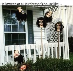 three creepy heads hanging from the side of a white picket fence in front of a house