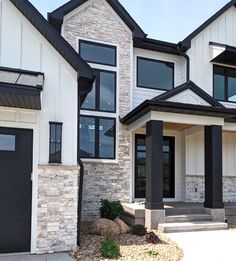 two story house with black and white trim on the front door, side entrance and entry steps