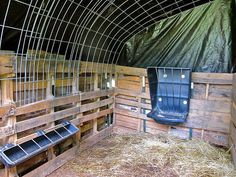 the inside of a barn with hay and plastic chairs