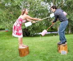 a man and woman are playing with jugs in the yard, one is on a tree stump