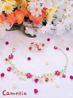 a necklace and earrings with flowers in the background